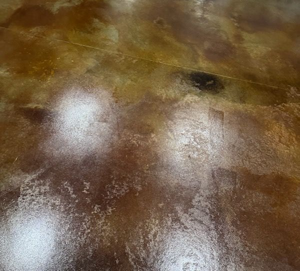 Metallic brown epoxy floor with swirling patterns and wooden trim.
