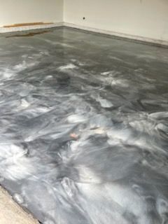 Metallic epoxy flooring in shades of gray and white swirled together.
