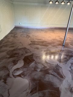 Metallic epoxy floor with brown and silver swirls in an empty room.