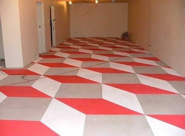 Optical illusion floor tiles, red, white, and gray, in an empty room.