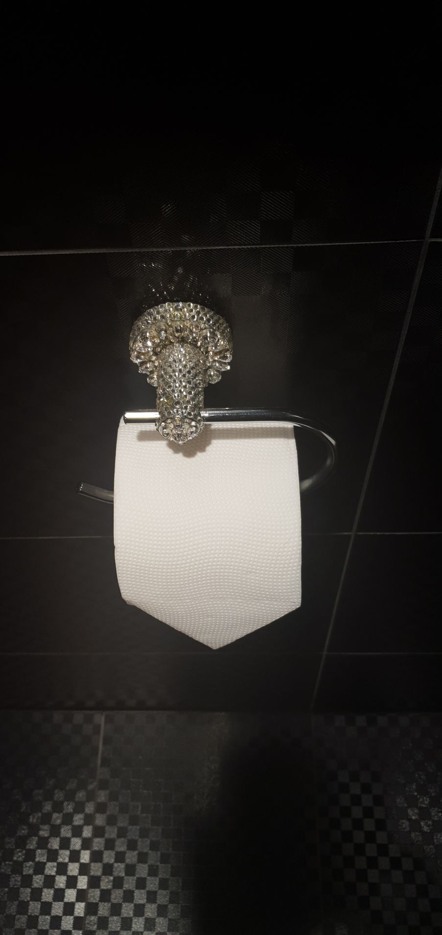 A roll of toilet paper is hanging on a toilet paper holder in a bathroom.