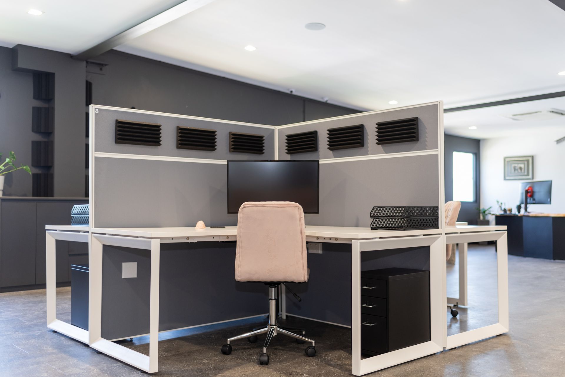 A cubicle with a chair and a computer on it.