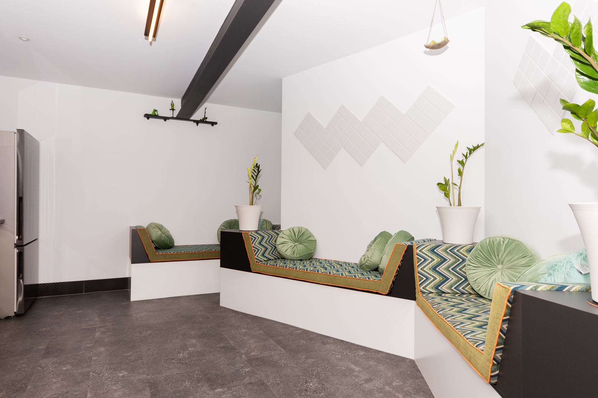 A room with a couch and a plant on the wall