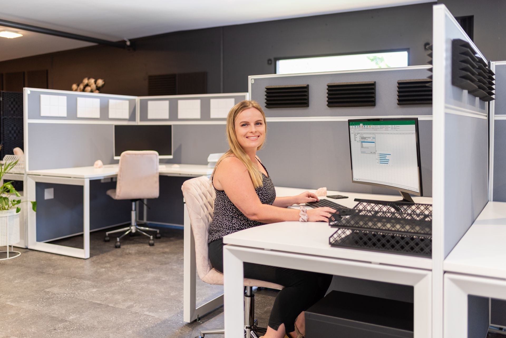 A woman is sitting at a desk in front of a computer.
