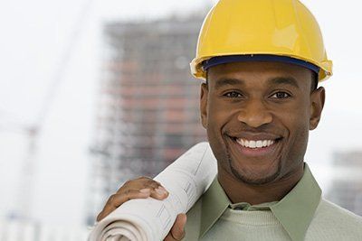 Man Smiling Wearing Safety Hat — Houston, TX — United Constructors Of Texas Inc