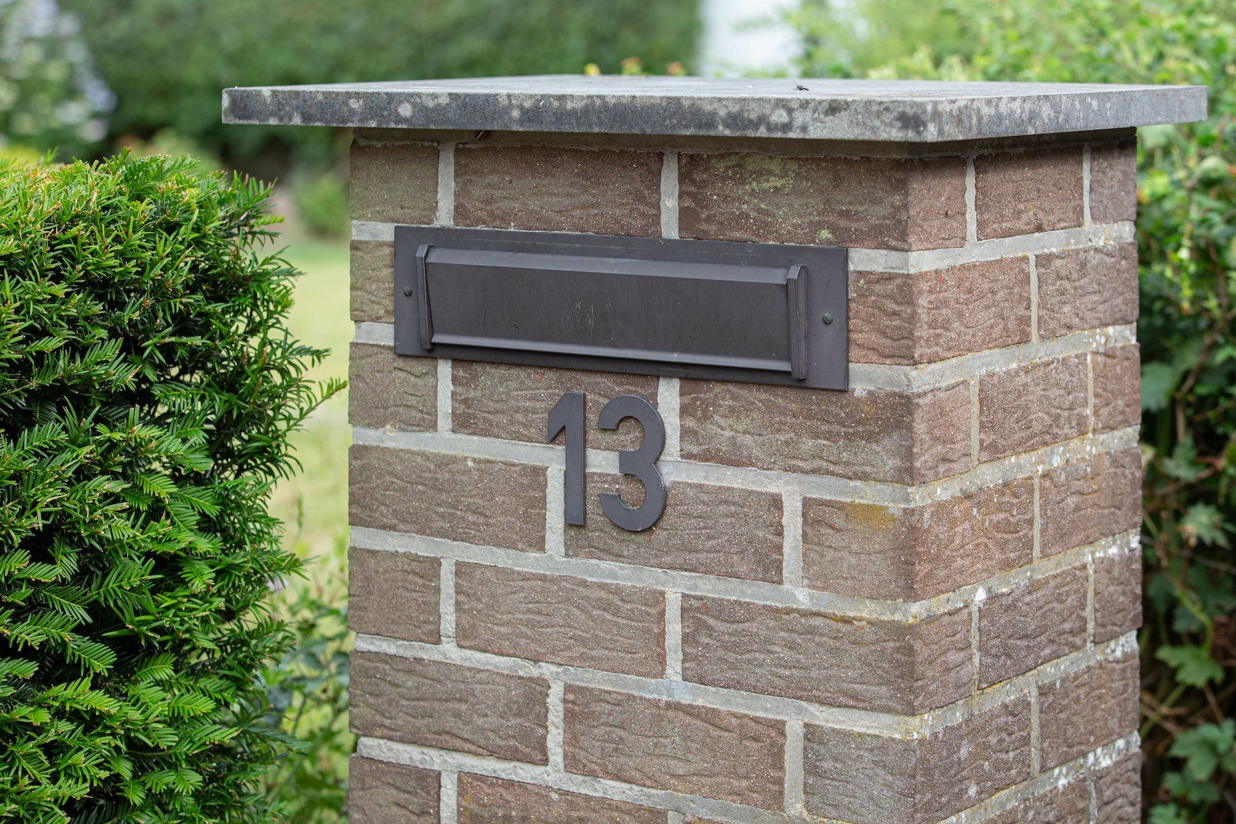 An elegant brick mailbox with a classic design, adorned with a secure mail slot.