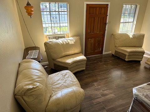 A living room with a couch and two chairs
