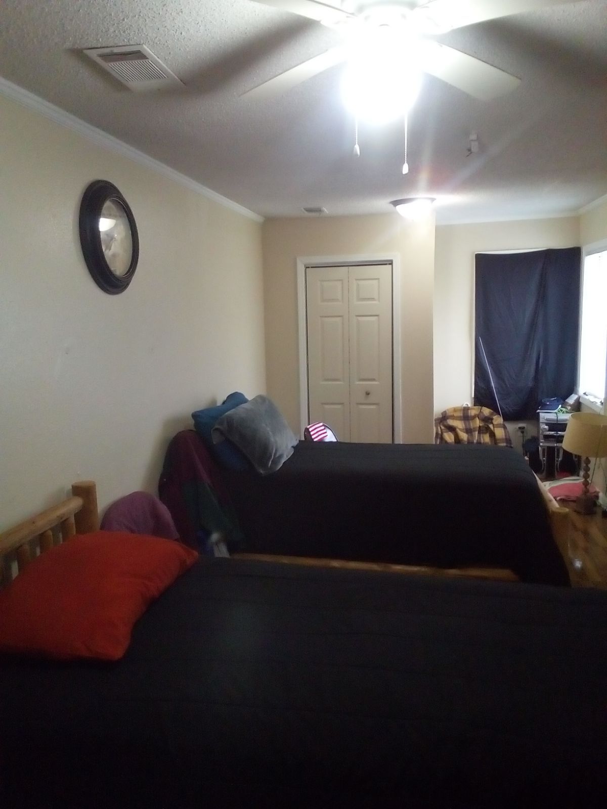 A bedroom with two beds and a ceiling fan