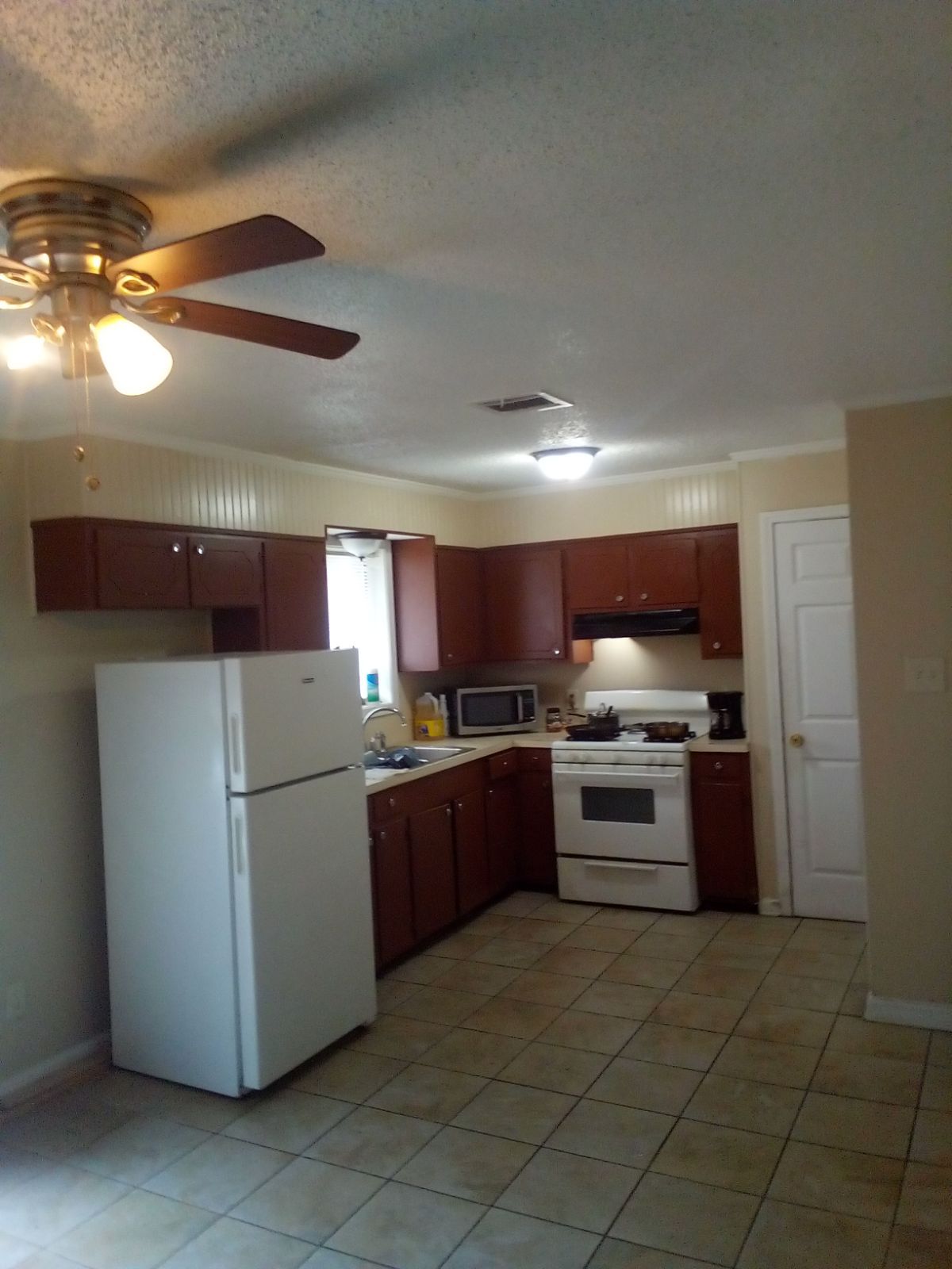 A kitchen with brown cabinets and a white refrigerator