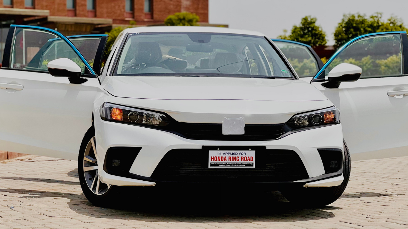 White sedan with open doors parked outside.