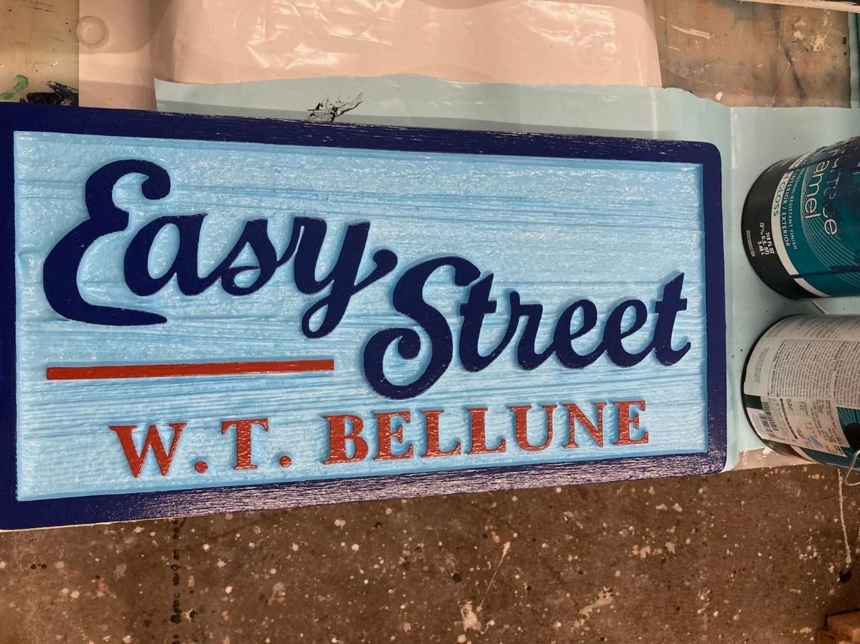 Blue sign reading “Easy Street” with “W.T. Bellune” in red, on a tiled surface