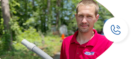 A man in a red shirt holding a vacuum hose outside, with a phone icon in a white circle.