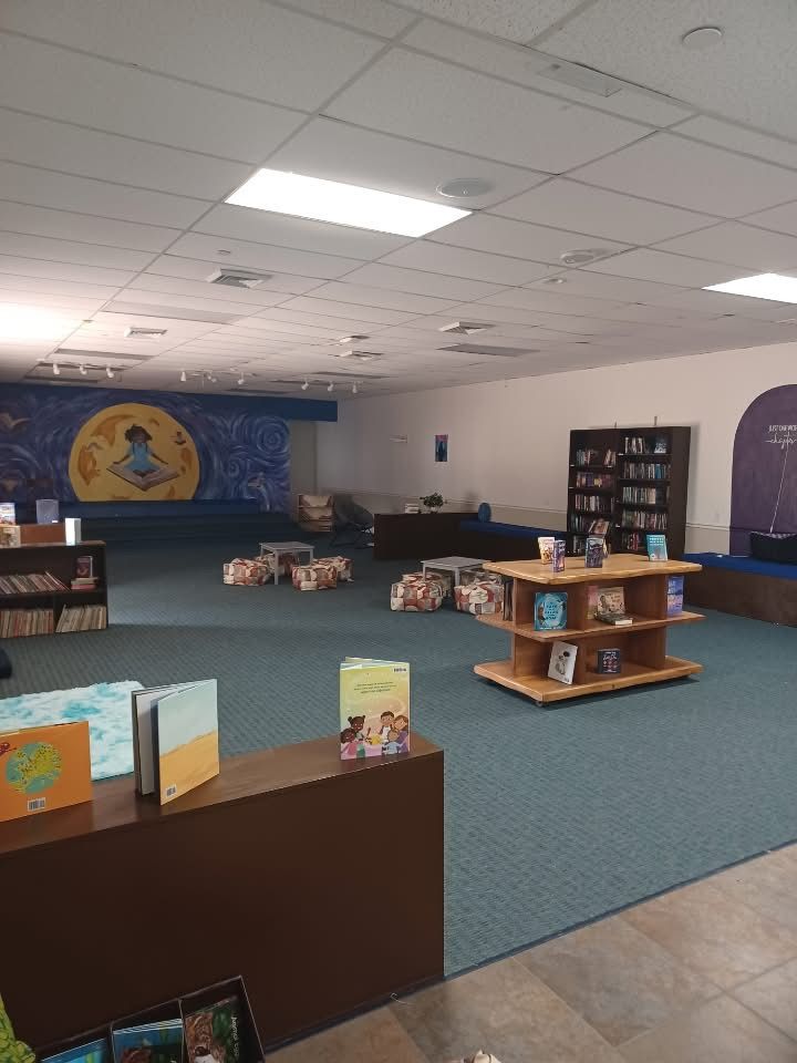 A children's library with bookshelves, blue carpet, and a starry mural.