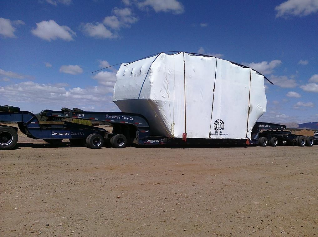 Semi-truck carrying oversized load across a narrow bridge; 