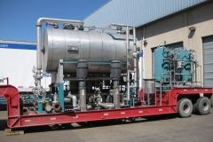 Large industrial equipment on a red trailer. Includes tanks, piping, pumps, and blue and silver components.