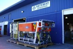 Orange machinery on a pallet outside the Gateway Logistics building. Blue building, white door.