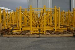 Yellow metal structures on wooden pallets outdoors, likely construction or industrial equipment.