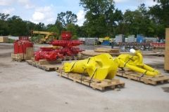 Large red and yellow industrial equipment on pallets in an outdoor storage yard.