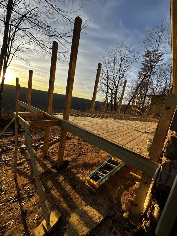 A wooden deck is being built on top of a dirt field.