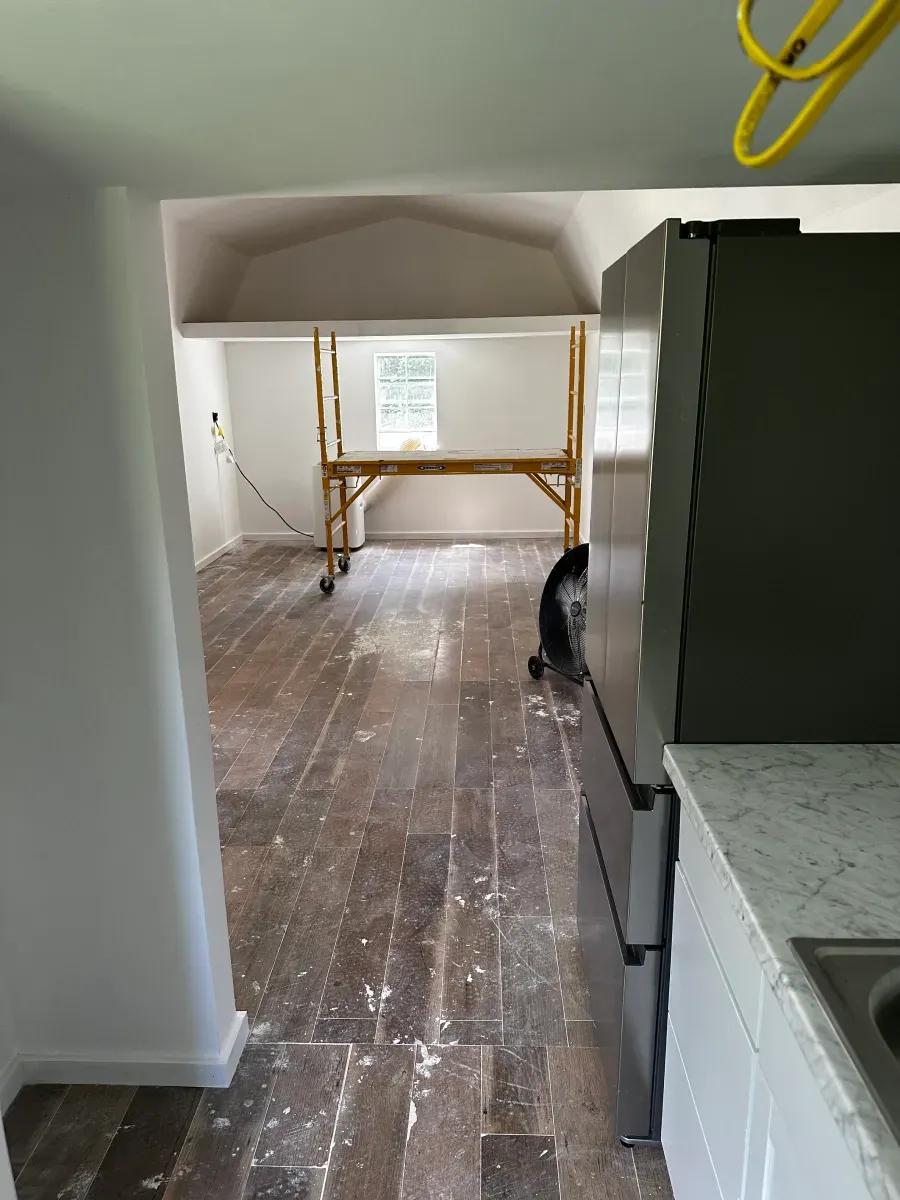 A kitchen with a refrigerator and a scaffolding in the background.