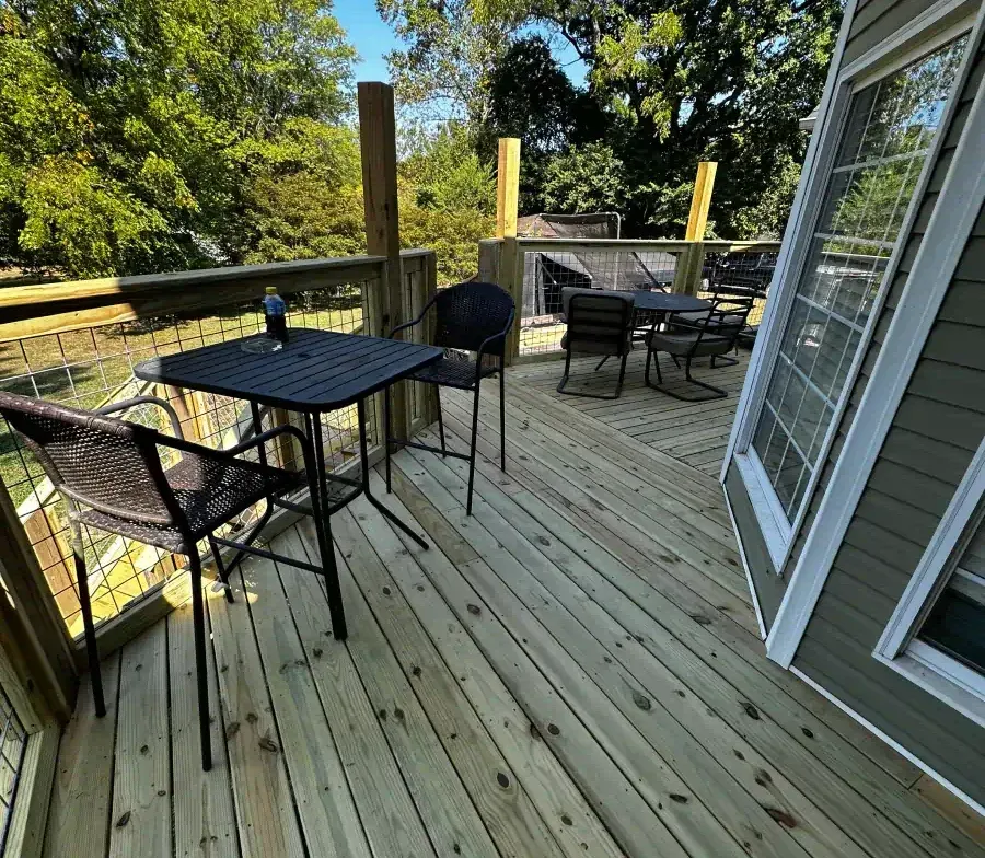 A wooden deck with a table and chairs on it