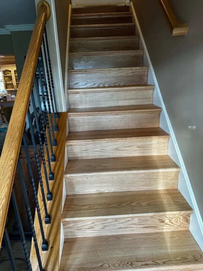 A wooden staircase with a metal railing in a house.