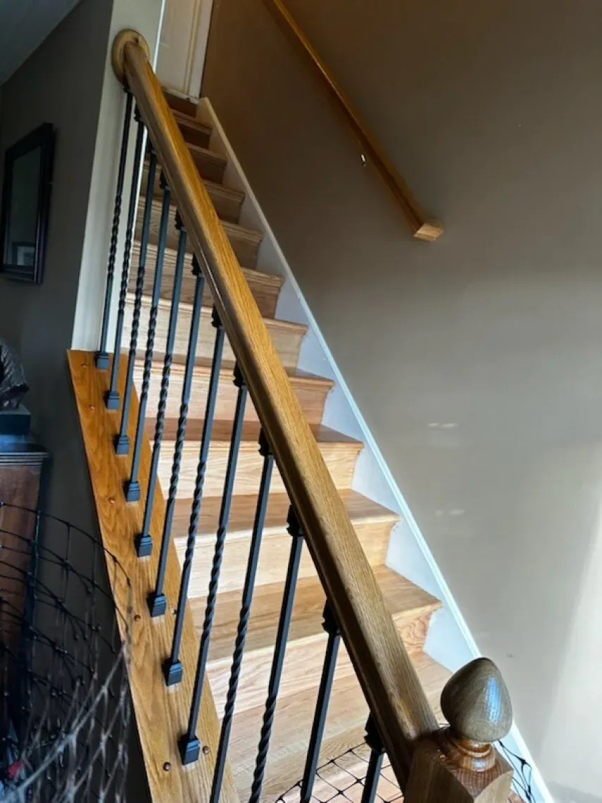A wooden staircase with a metal railing in a house