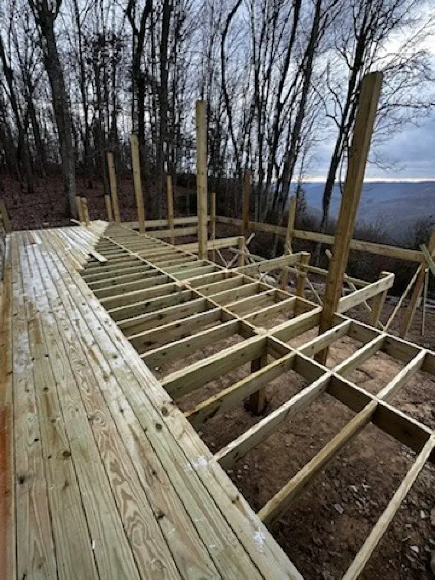 A wooden deck is being built in the woods.