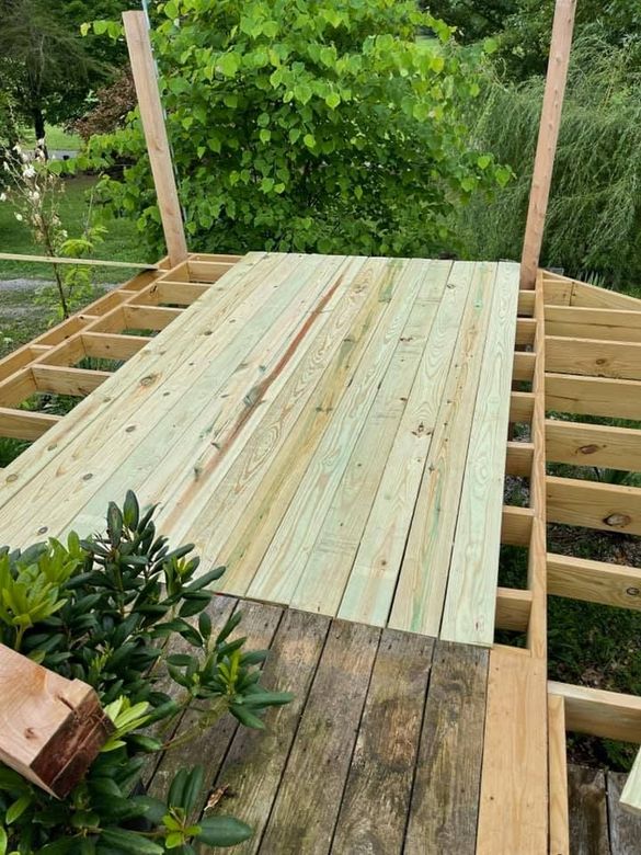 A wooden deck is being built in the backyard.