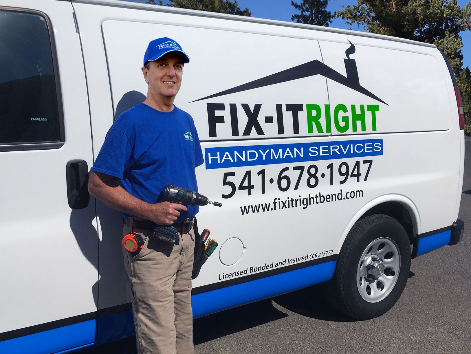 A row of suburban homes with tan siding, stone pillars, and dark grey roofs under a bright blue sky.