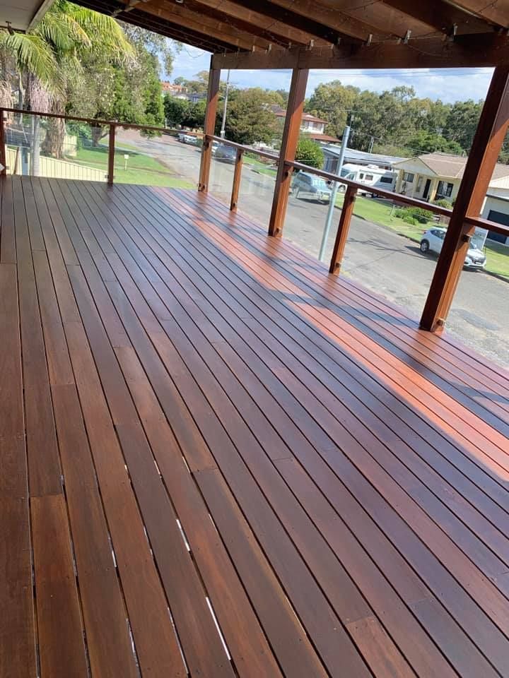 Wooden Deck With Brown Planks and Glass Railing Overlooking a Residential Street — Custom Floor Sanding In Terrigal, NSW