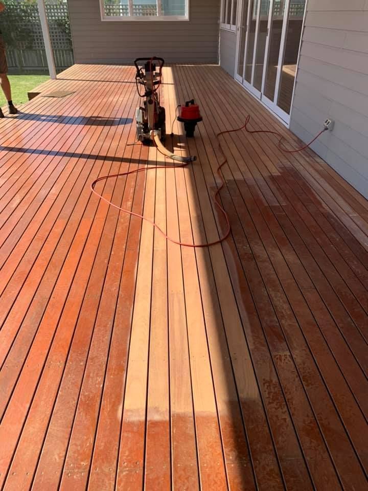 A large, outdoor wooden deck undergoing refinishing, with a sanding machine and power cord visible on the boards — Custom Floor Sanding In Somersby, NSW