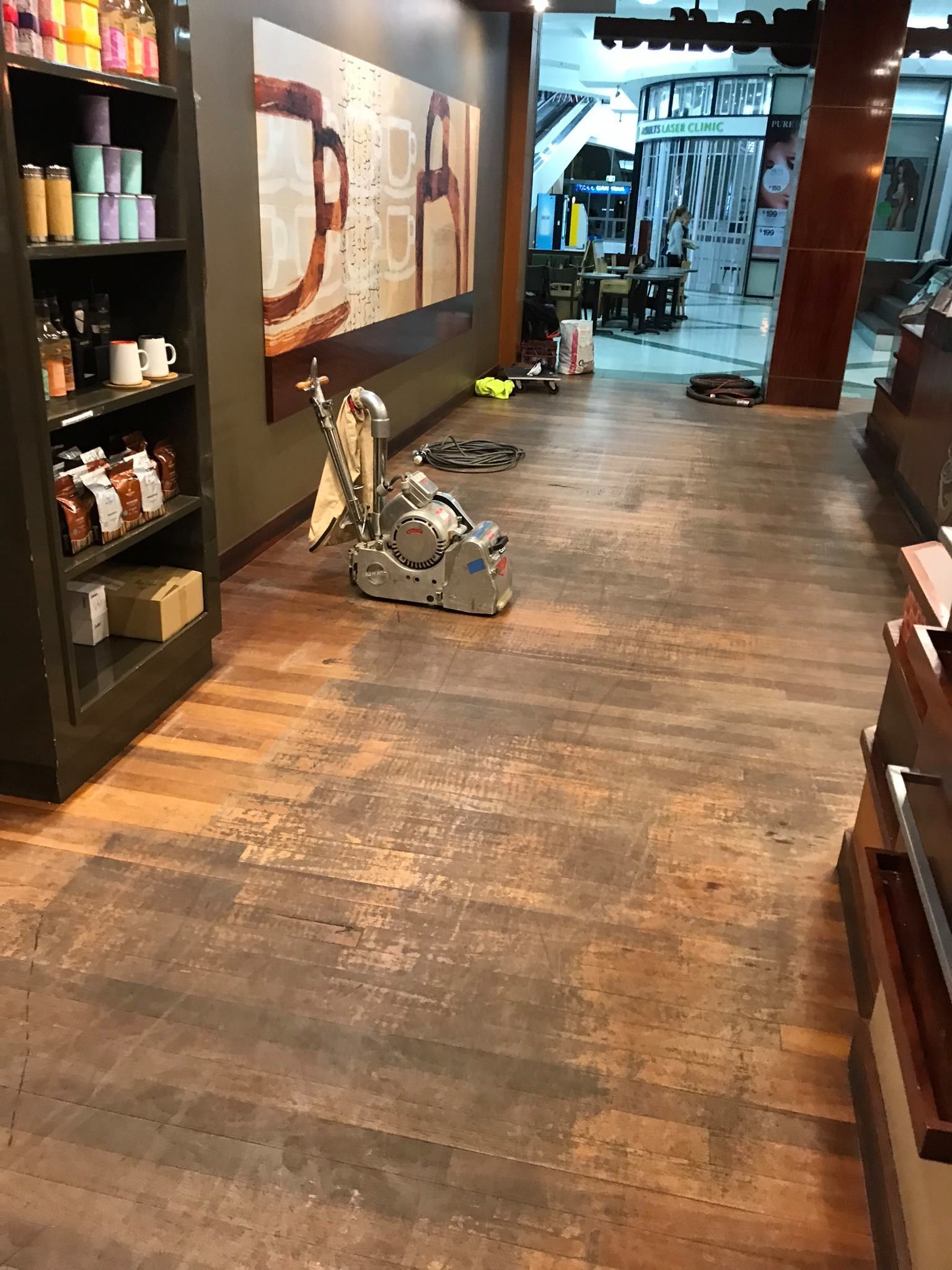 A Coffee Shop Interior With a Floor Sander — Custom Floor Sanding In Somersby, NSW