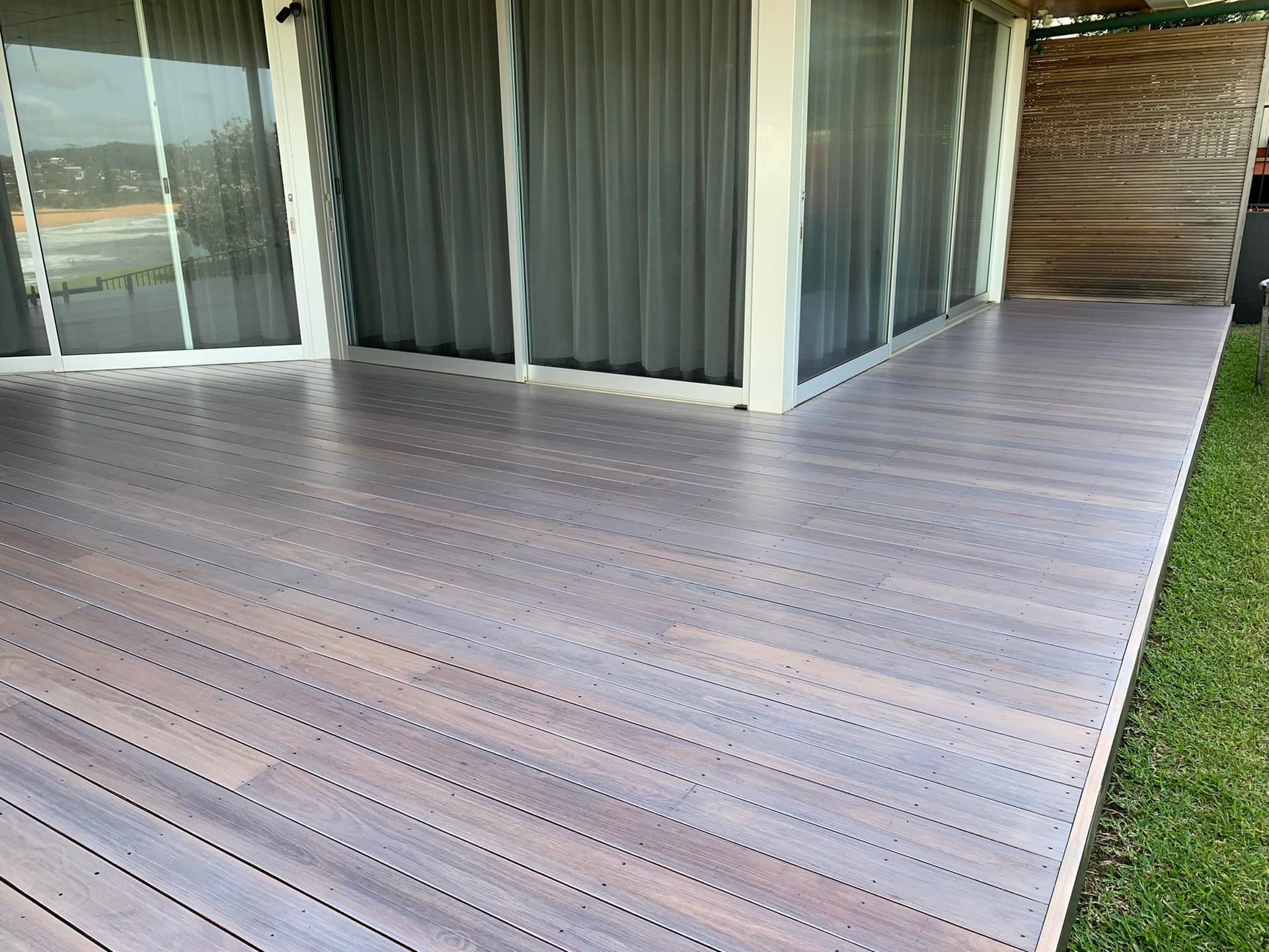 Wooden deck with dark grey-brown planks — Custom Floor Sanding In Somersby, NSW