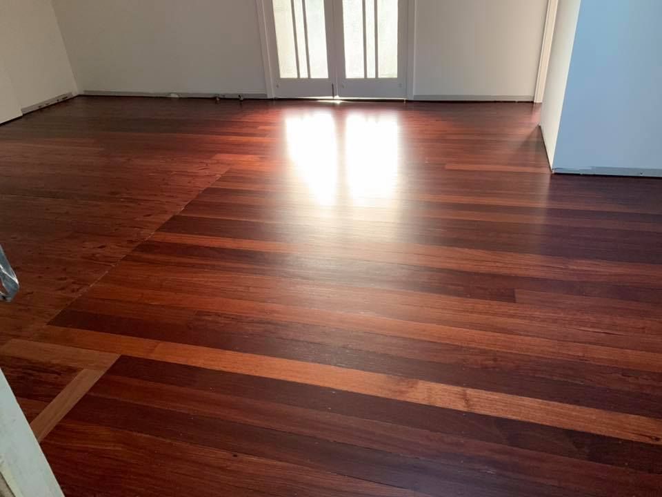 Shiny, Dark Hardwood Floor Reflecting Light, Doors in Background — Custom Floor Sanding In Wyong, NSW