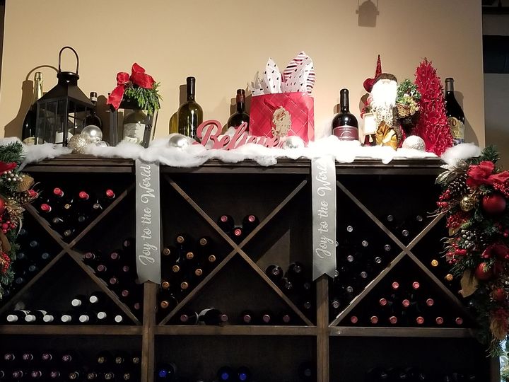 A wine case topped with Christmas decorations and a ribbon that says Joy to the World