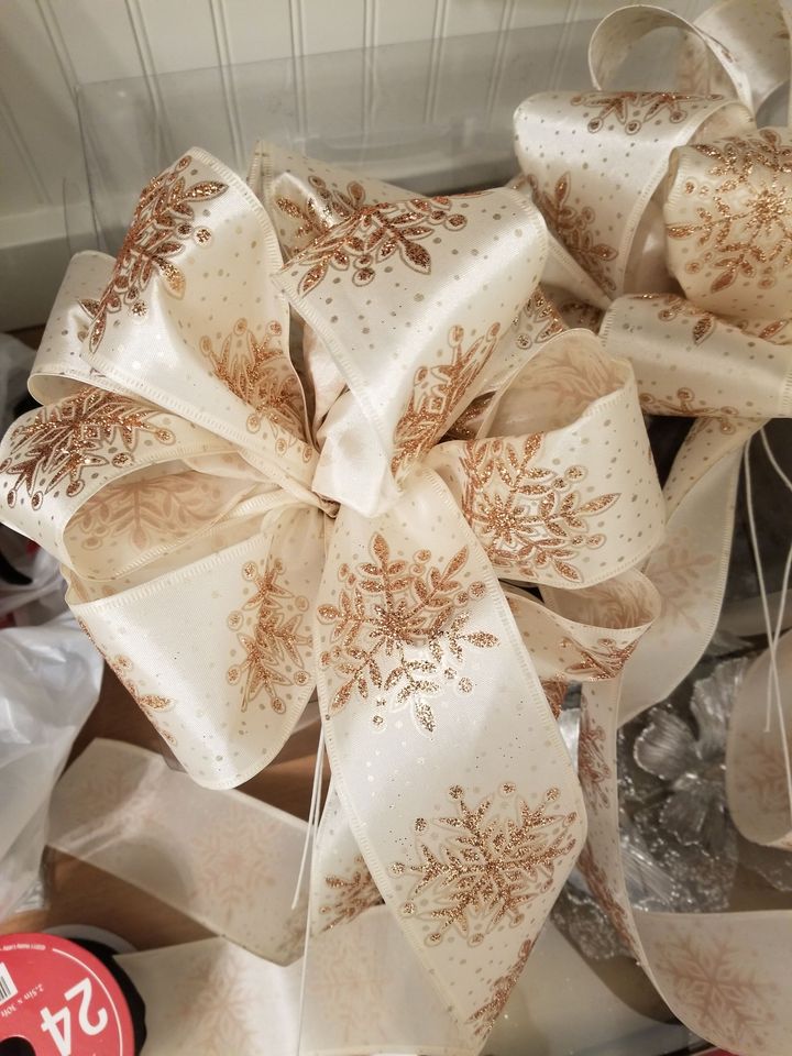 A large white Christmas bow with gold snowflakes