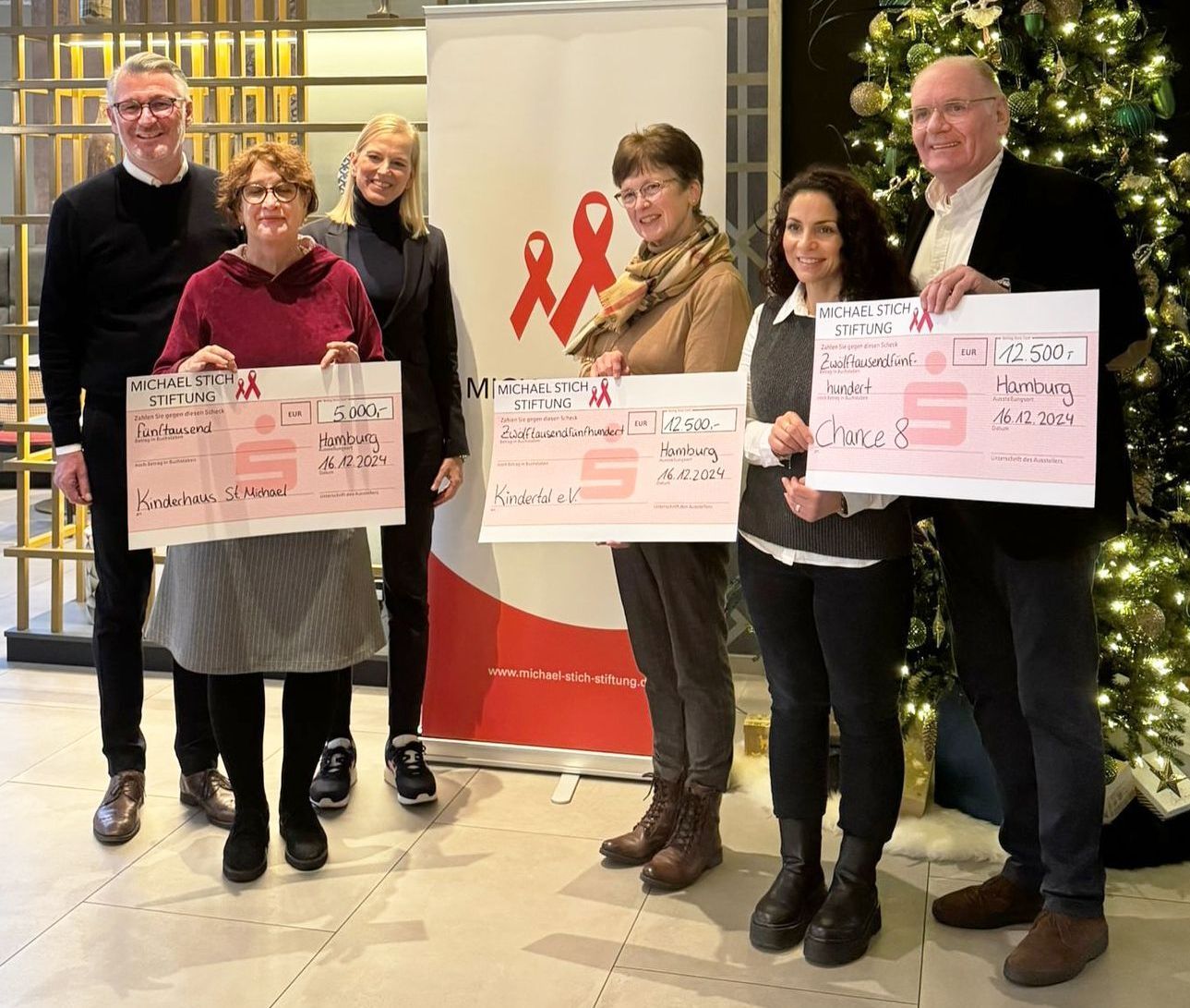 Gruppenbild im Foyer des Postboutique Hotels: Arnd Vesper und Anke Hartmann bei der Übergabe des Spendenchecks an Bahar Celik und Rainer Giehler.  