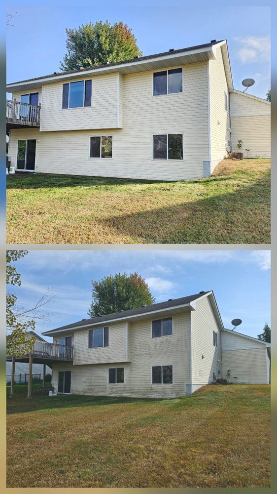 Two-story cream-colored house on a grassy lawn under a partly cloudy sky.