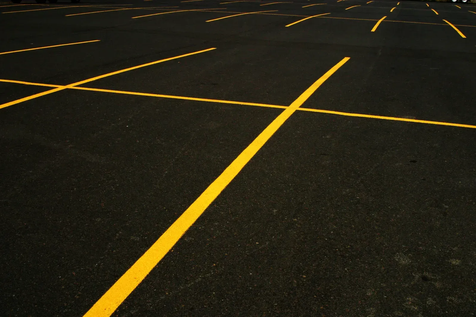 Yellow parking space lines on a dark asphalt surface.