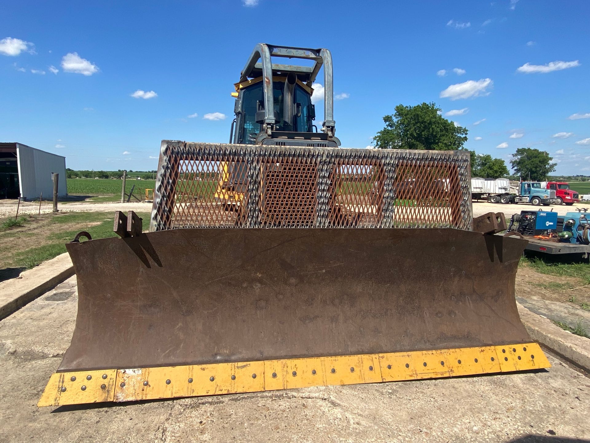 a bulldozer is parked in a field with a blue sky in the background
