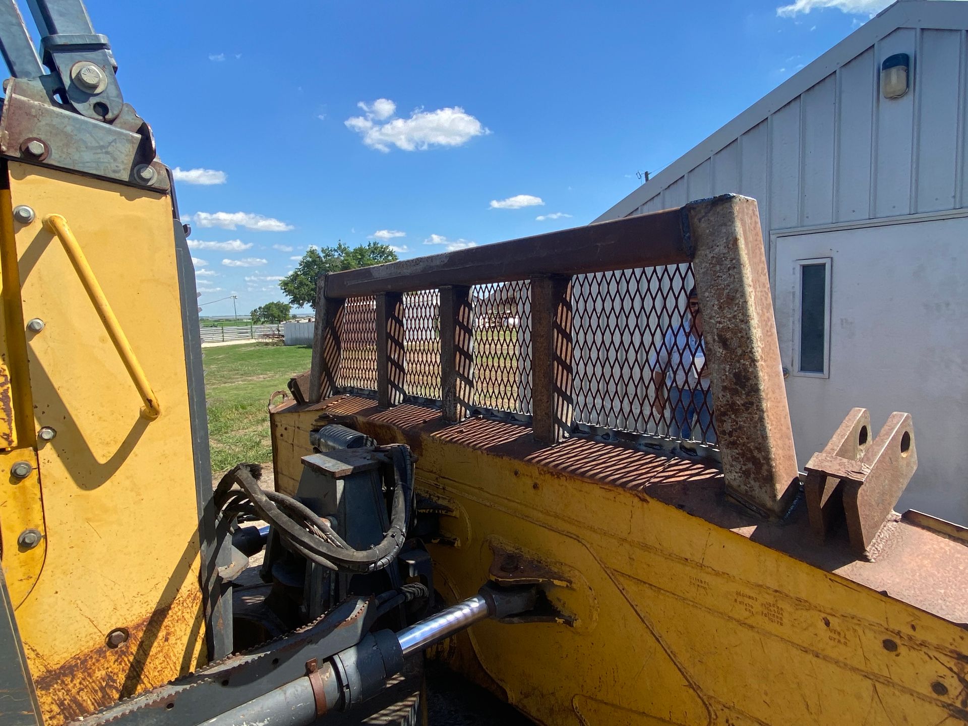 a yellow bulldozer is parked in front of a white building .