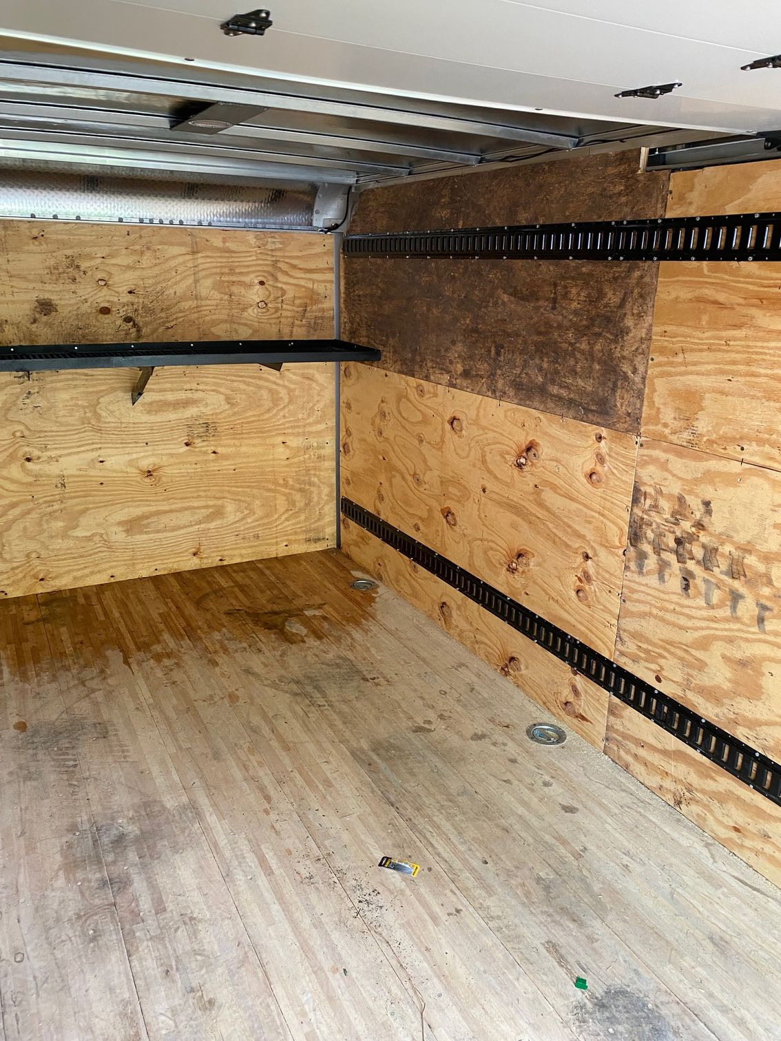 the inside of a truck with wooden walls and a wooden floor .