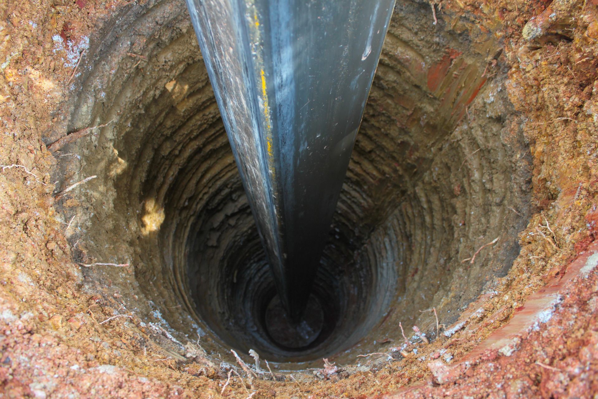A large hole in the ground with a pipe coming out of it.