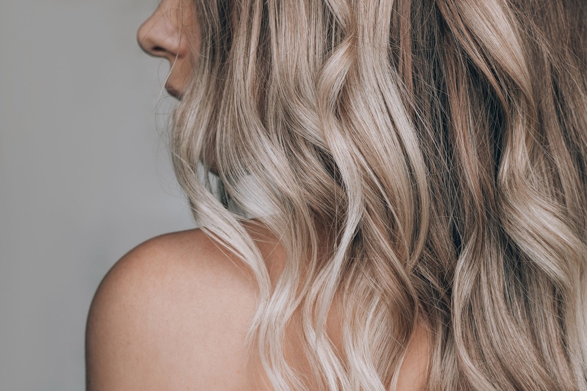 A close-up of a woman's back with long blonde hair.