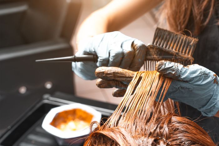 A woman is getting her hair dyed in a salon.