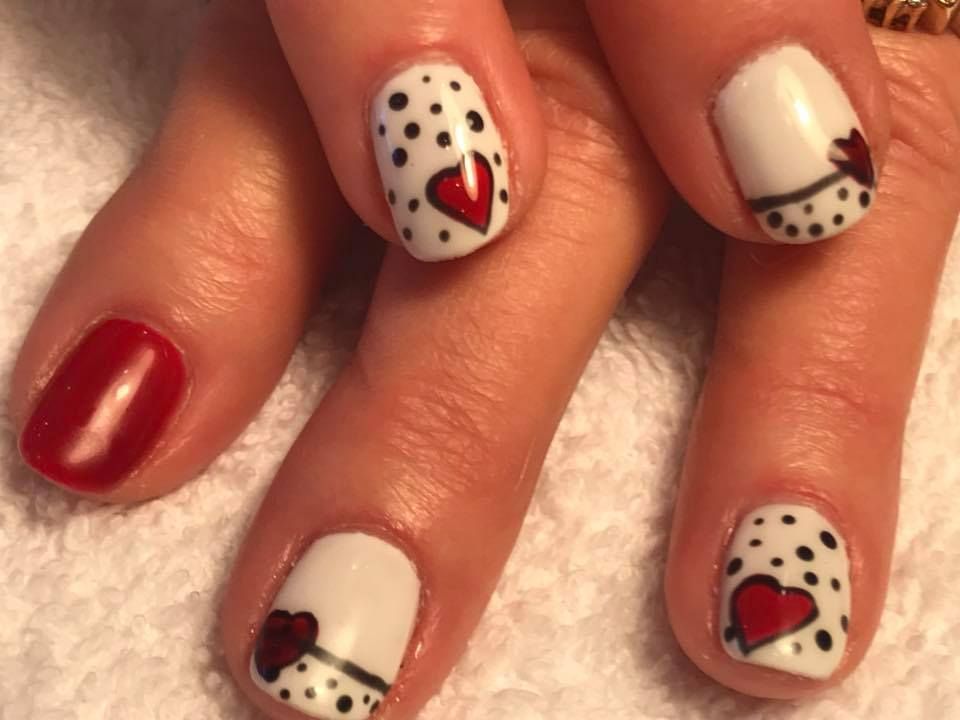 A close-up of a person's nails with hearts on them.