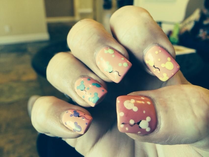 A close-up of a woman's nails with a Mickey Mouse design