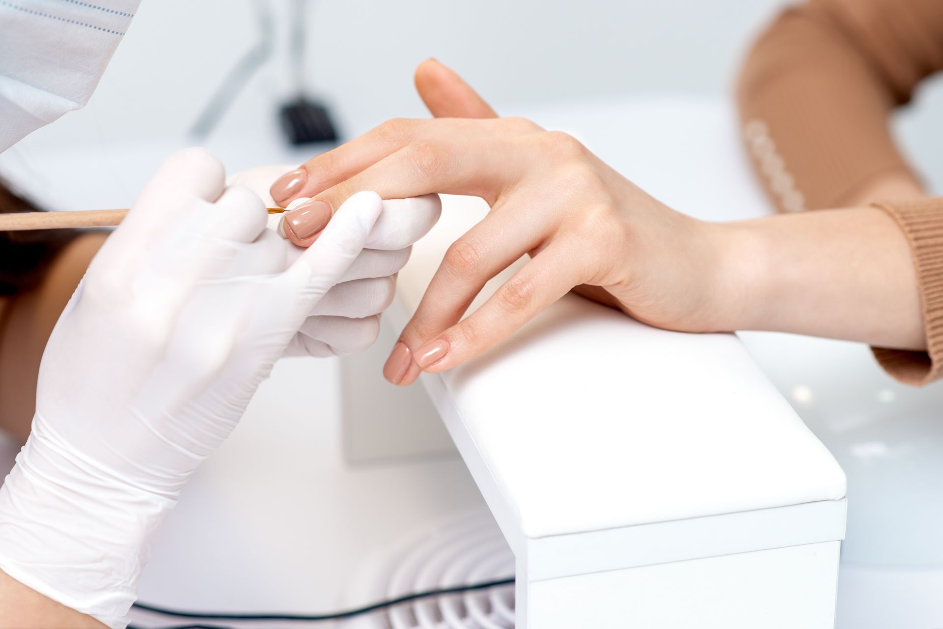 A woman is getting her nails done at a nail salon.