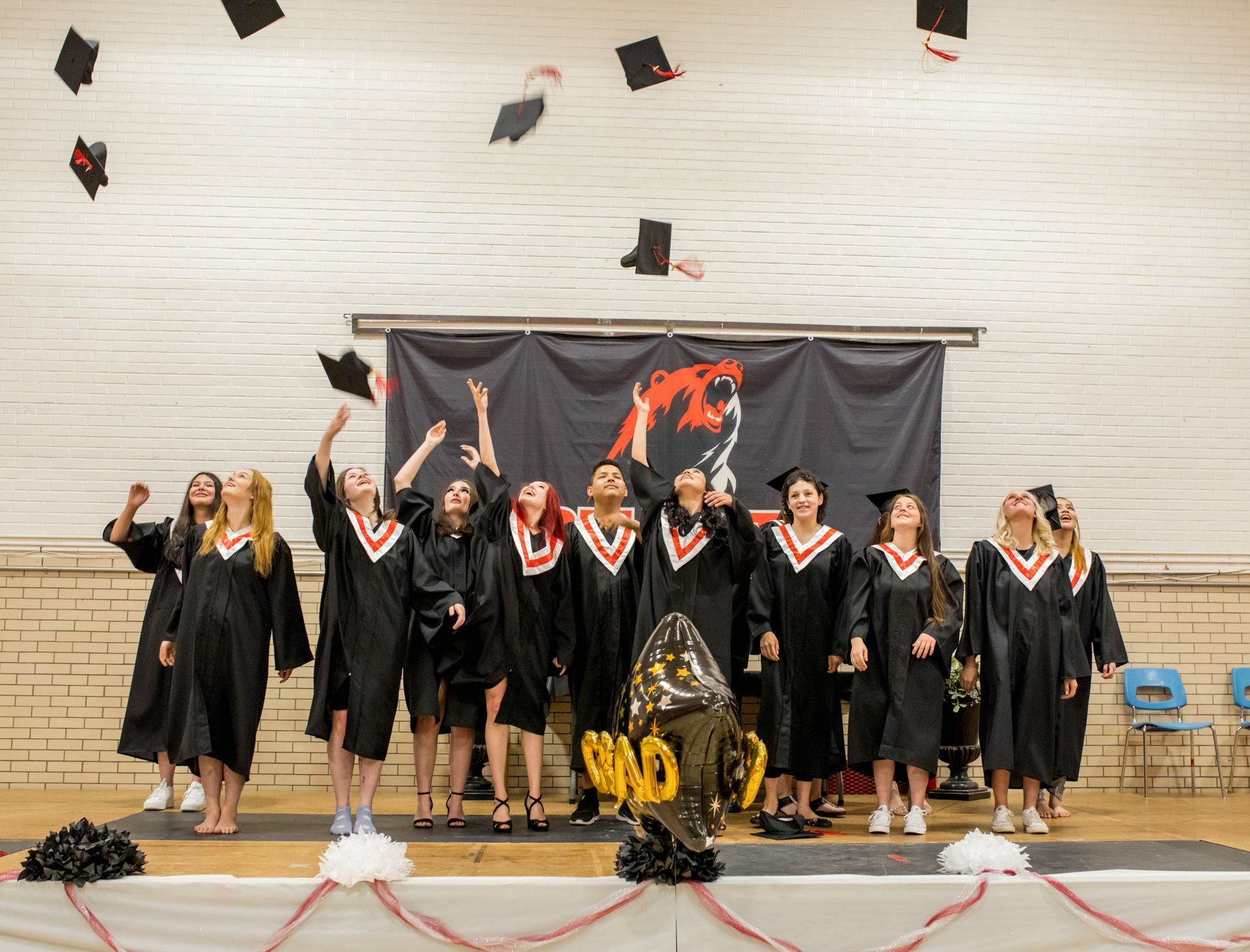 A group of graduates are throwing their caps in the air.